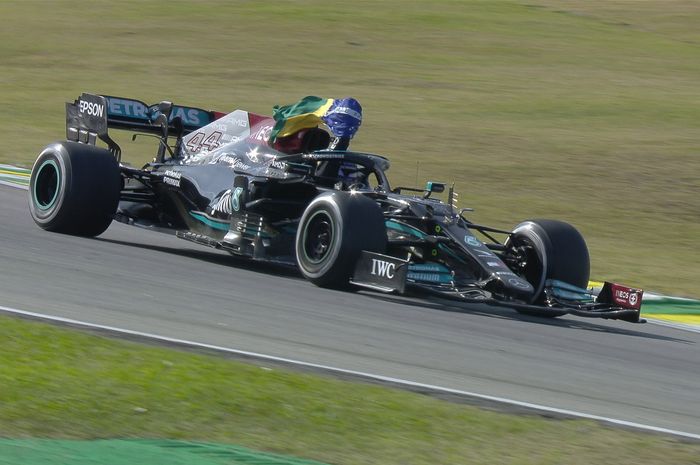 Lewis Hamilton melambaikan bendera Brasil saat victory lap menuju parc ferme di F1 Brasil 2021