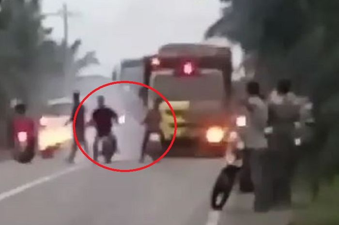 Tuh dua pembalap liar yang dilingkari warna merah di belakangnya truk terpaksa stop