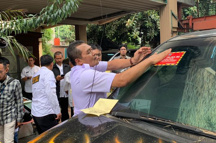 Wakil Kepala BPRD memasang stiker tanda belum membayar pajak (6/12/2019).