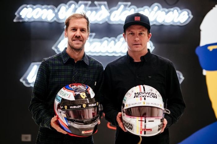 Sebastian Vettel (kiri) bertukar helm dengan Kimi Raikkonen (kanan)
