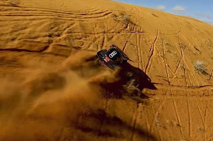Carlos Sainz bawa mobilnya merambat di permukaan curam sebuah bukit pasir di Reli Dakar 2023