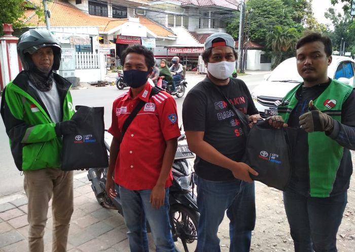 Pembagian paket sembako dan masker kain dari member AXIC kepada para driver Ojol