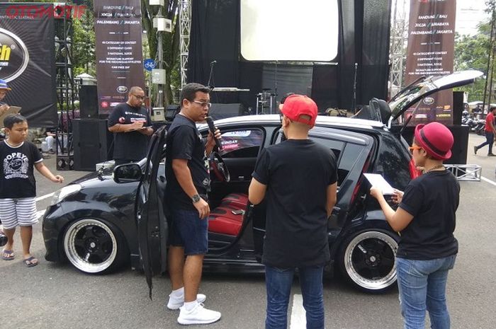 Peserta mempresentasikan modifikasi mobilnya di depan panggung