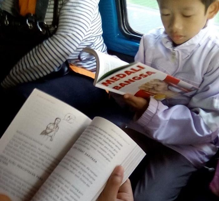 Anak Kecil Baca Buku Di Angkot Baca