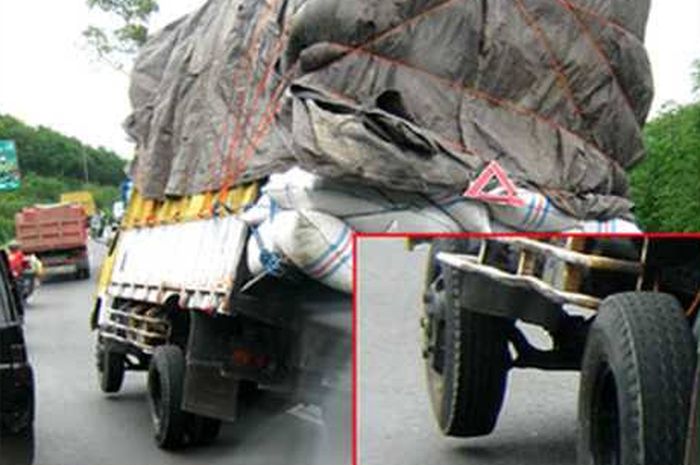 Ilustrasi bahaya truk overload dengan ban depan yang mengangkat.