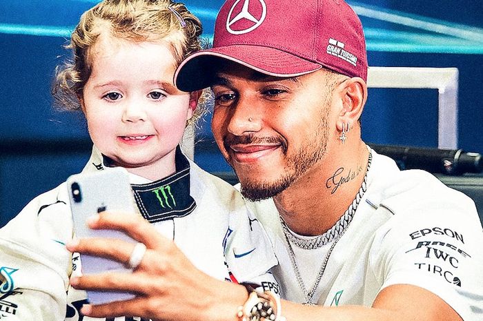 Lewis Hamilton swafoto dengan penggemar ciliknya, Leila McKay (3 tahun) di F1 Singapura