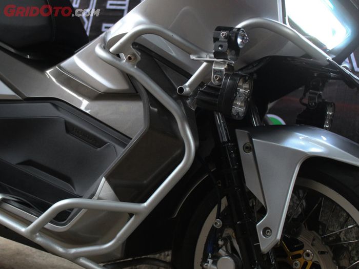 Crashbar custom plus lampu tambahan terpasang di bodi Honda ADV 150 touring ini.