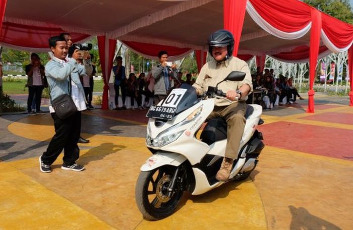 Gubernur Sumatera Selatan Alex Noerdin menjajal Honda PCX saat acara penyerahan 50 unit Honda PCX dari Astra Motor Sumsel kepada panitia penyelenggara Asian Games 2018 Palembang, di Jakabaring Sport City, Senin (23/7/2018). Secara simbolis, penyerahan dilakukan oleh Kepala Wilayah Astra Motor Sumsel, Ronny Asgustinus.(Astra Motor Sumsel)