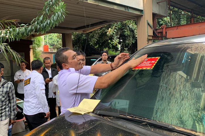Wakil Kepala BPRD memasang stiker tanda belum membayar pajak (6/12/2019).
