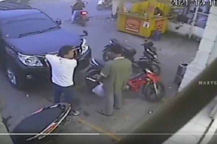 Tangkap layar CCTV yang memperlihatkan seorang pengemudi mobil pukul remaja di parkiran minimarket.  