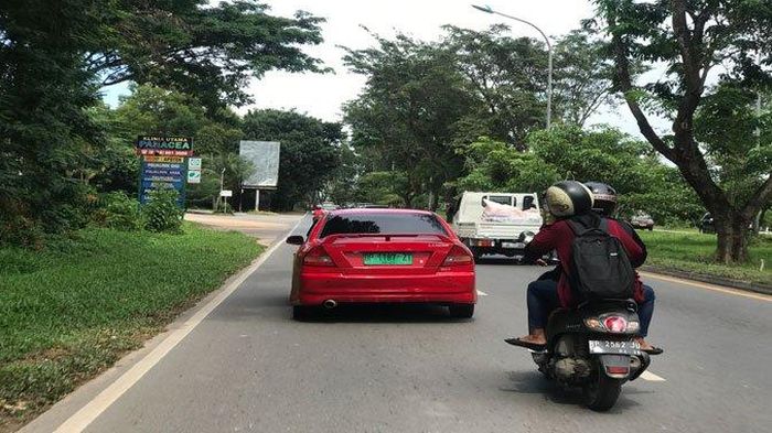 Mitsubishi Lancer melintas di jalanan kota Batam, Kepulauan Riau memakai pelat nomor hijau