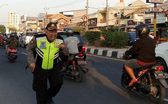 Kapolsek Kedawung Kompol Tutu Mulyana berjoget sambil mengatur lalu lintas. Aksinya menghibur pemudik