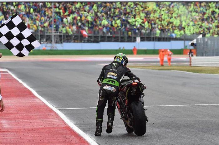 Johann Zarco mendorong motornya ke garis finish