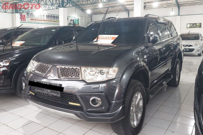 Ilustrasi Mitsubishi Pajero Sport generasi kedua di showroom mobil bekas.