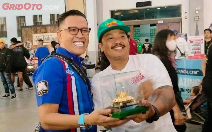 Yayack (kanan) dengan bangga memamerkan Piala Raja Sri Sultan Hamengkubono X seusai raih Best Kustom Bike di Kustomfest 2022