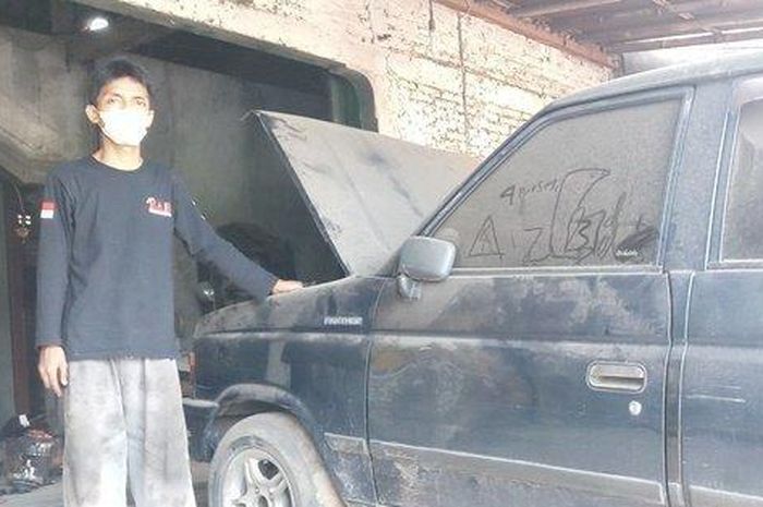 Gempar Aprilianto (kiri) bersama Isuzu Panther pelanggan yang ditinggal sebulan di depan bengkelnya