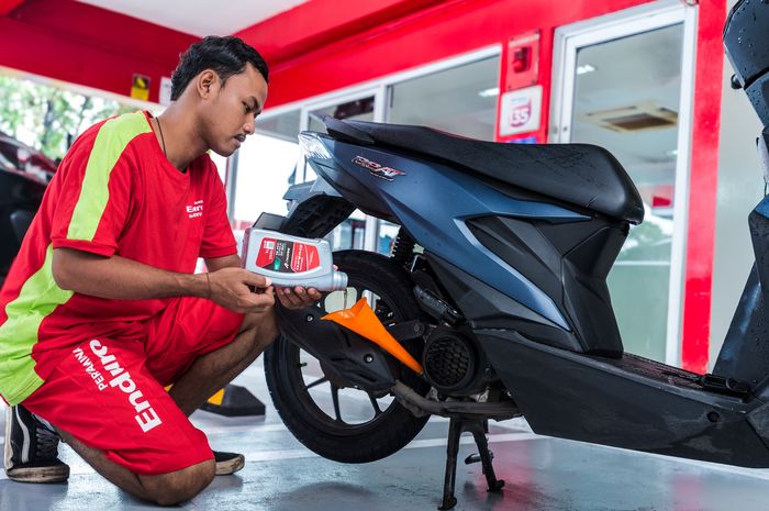 Ilustrasi penggantian oli mesin motor menggunakan Pertamina Enduro.