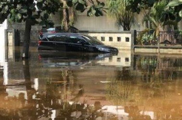 Toyota Kijang Innova dibiarkan terendam banjir rob di kawasan perumahan elit Pantai Mutiara, Pluit, Penjaringan, Jakarta Utara