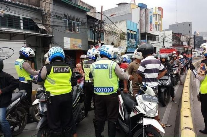 Sejumlah petugas Satgas Sterilisasi Jalir Busway Satlantas Jakarta Timur menilang sejumlah pengendara motor karena melintasi jalur busway di ruas Jalan Jatinegara Barat, Jakarta Timur, Rabu (13/3)
