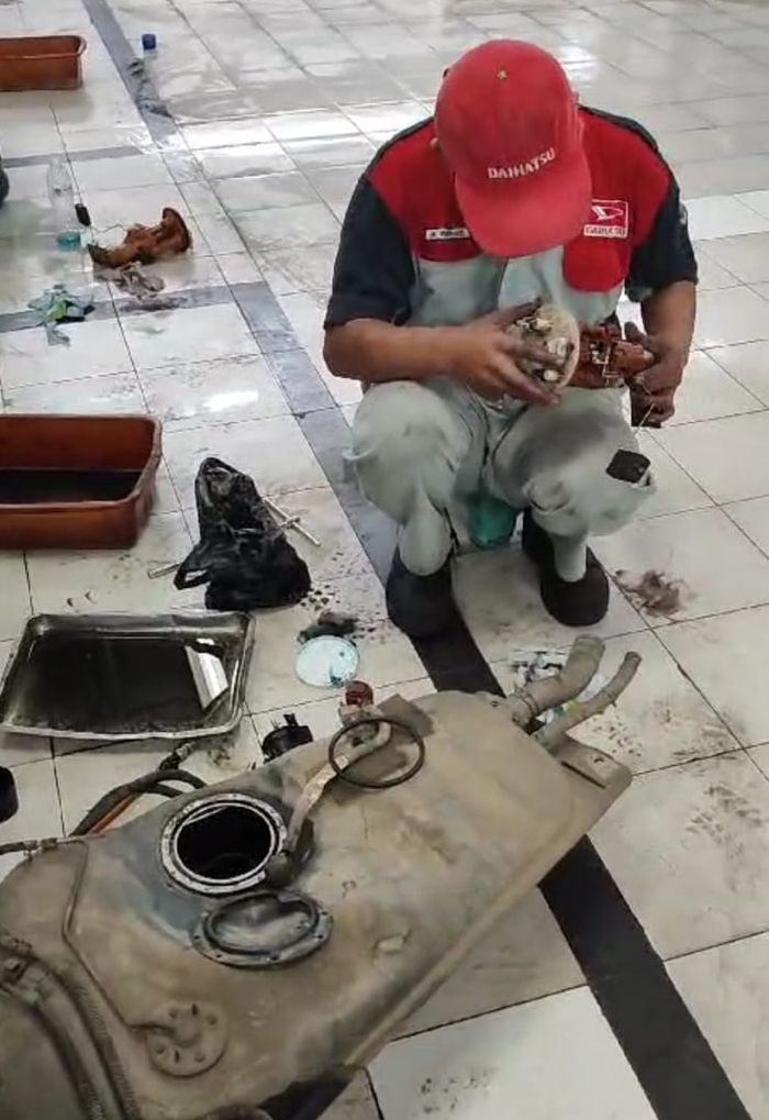 Mekanik Daihatsu sedang memeriksa kerusakan pompa bensin 