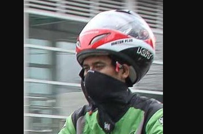 Kang ojek dengan helm merchandise Motor Plus.