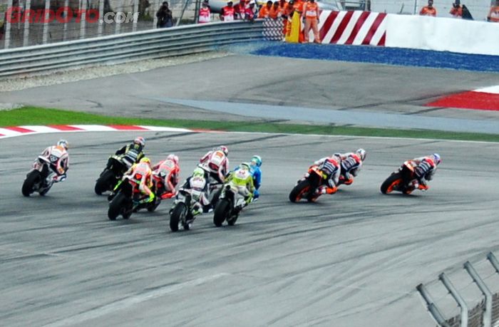 Lap pertama MotoGP Malaysia 2011, Marco Simoncelli (kelima dari kanan depan) memasuki tikungan pertama sirkuit Sepang