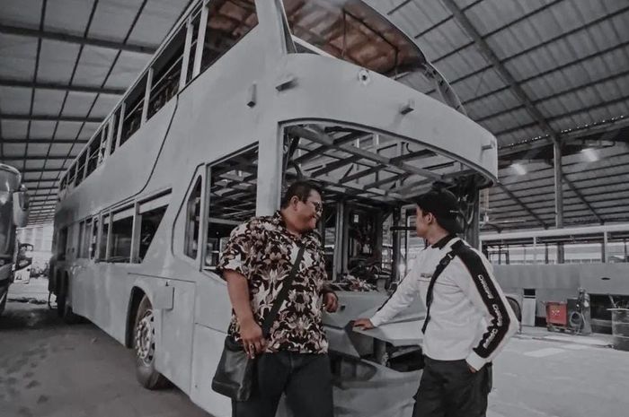 Rian Mahendra (kiri) berfoto di depan bus double decker baru PO Kencana.