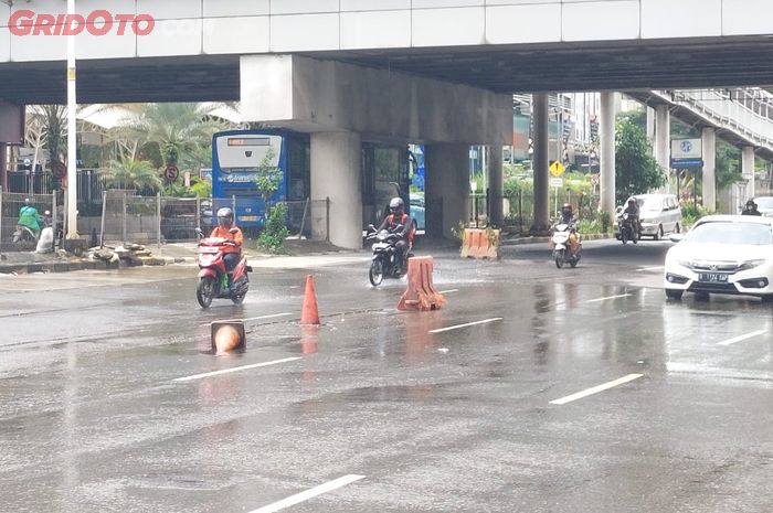 Jalan berlubang dan basah di depan Pondok Indah Mall.