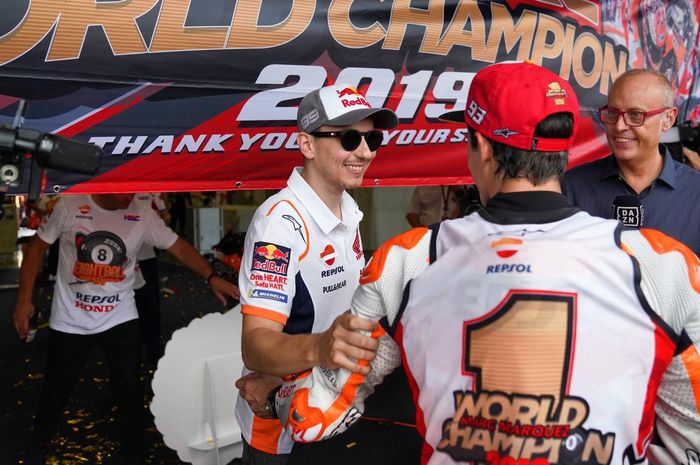 Pembalap Repsol Honda, Jorge Lorenzo, memberikan ucapan selamat pada rekan setimnya, Marc Marquez, usai mengunci gelar dunia di MotoGP Thailand