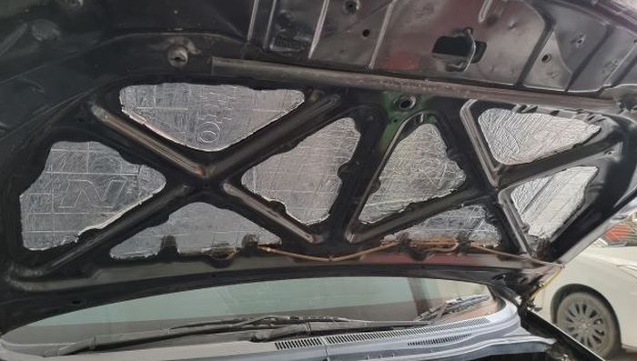 Ilustrasi peredam isolator dipasang di balik kap mesin