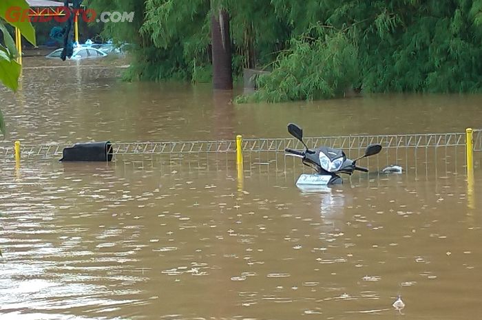 Satu unit Honda Supra X 125 terlihat terendam banjir, begitu pun dengan mobil taksi Bluebird berjenis Toyota Limo. Motor yang terendam banjir harus segera dikuras tangkinya