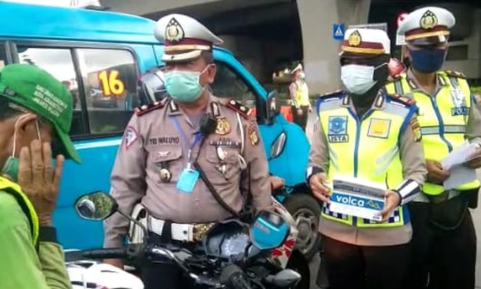 Kasi Gar Ditlantas Polda Metro Jaya, Kompol Tri Waluyo saat membagikan masker pada kegiatan Operasi Keselamatan Jaya 2020