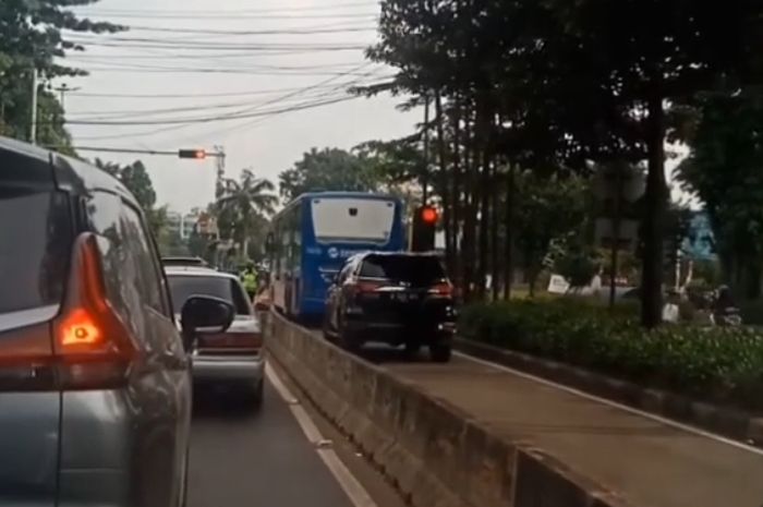Mobil Fortuner yang lolos melewati jalur Transjakarta dengan pelat RFY