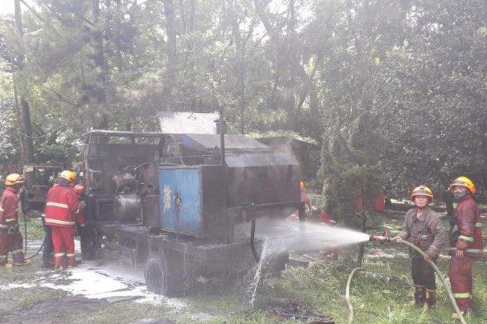 Petugas Diskar PB tengah memadamkan api yang membakar truk pengolah aspal di Taman Pramuka, Kota Bandung. 