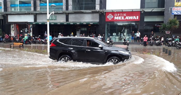 Ilustrasi mobil menerjang banjir.