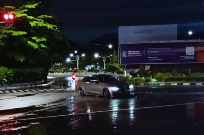 Aksi drifting BMW Seri 3 warna hitam di Simpang Pondok Indah Mall, Kebayoran Lama, Jakarta Selatan