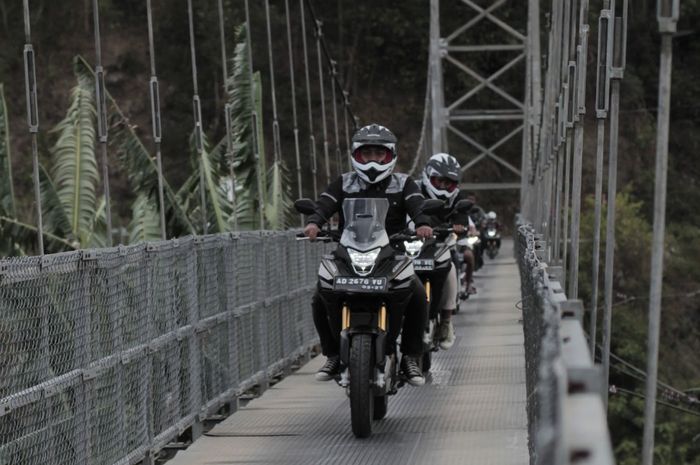 Rombongan melewati jembatan gantung menggunakan Honda CB150X