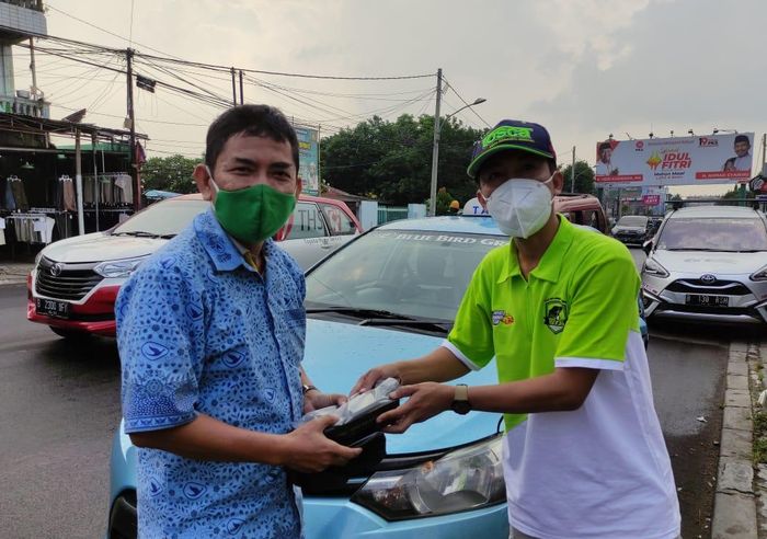 Komunitas mobil TOSCA membagikan masker dan makan siang ke sopir angkutan umum