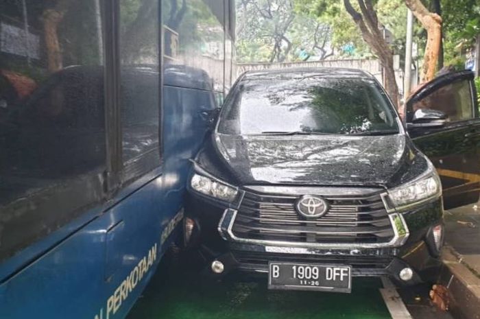 Toyota Kijang Innova serempetan dengan bus TransJakarta hingga kejepit di Jl Jenderal Sudirman arah Bundaran Senayan, Semanggi, Jakarta Selatan