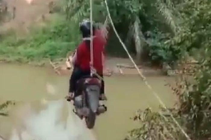 Pengendara melayang menyeberangi sungai