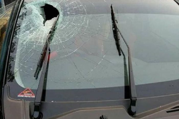 Ilustrasi pelemparan batu ke mobil