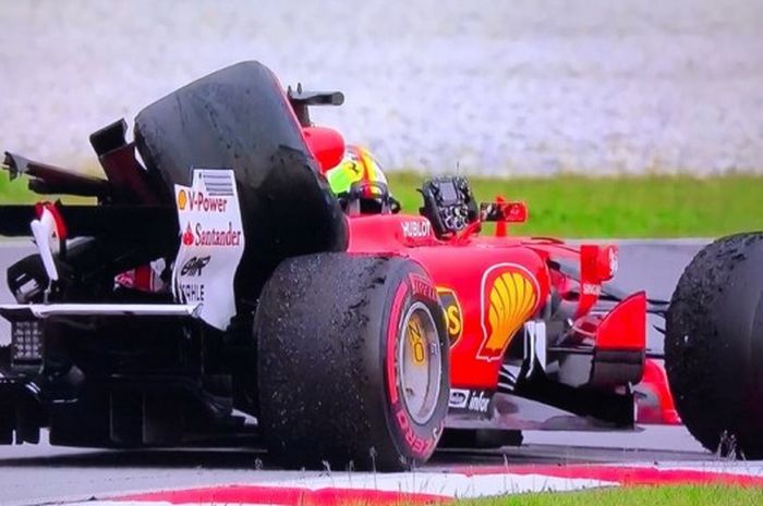 Ban belakang mobil Sebastian Vettel terlipat ke atas badan mobil akibat senggolan dengan Lance Stroll