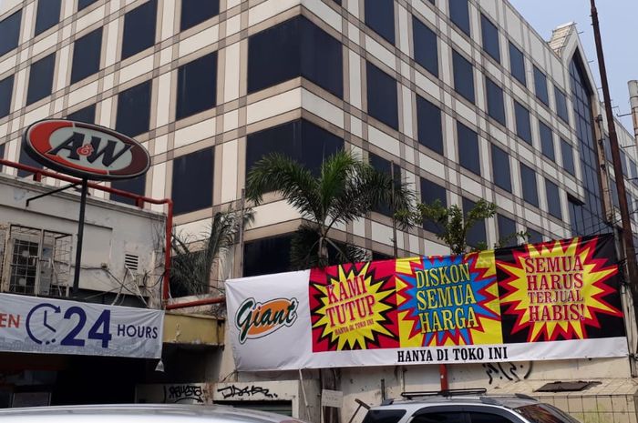 Spanduk berisikan pemberitahuan kalau toko swalayan Giant yang tutup mengadakan diskon. 