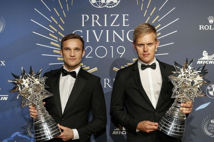 Ott Tanak (kanan) dan Martin Jarveoja menerima trofi dari FIA atas keberhasilan mereka jadi juara dunia reli 2019