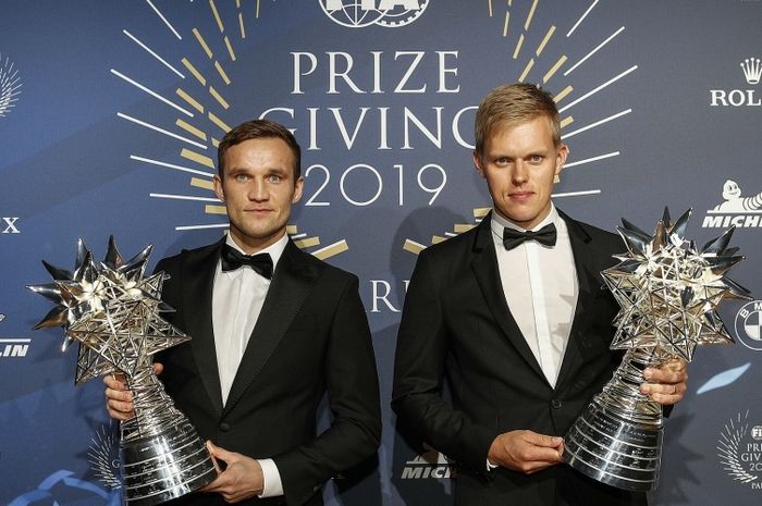 Ott Tanak (kanan) dan Martin Jarveoja menerima trofi dari FIA atas keberhasilan mereka jadi juara dunia reli 2019
