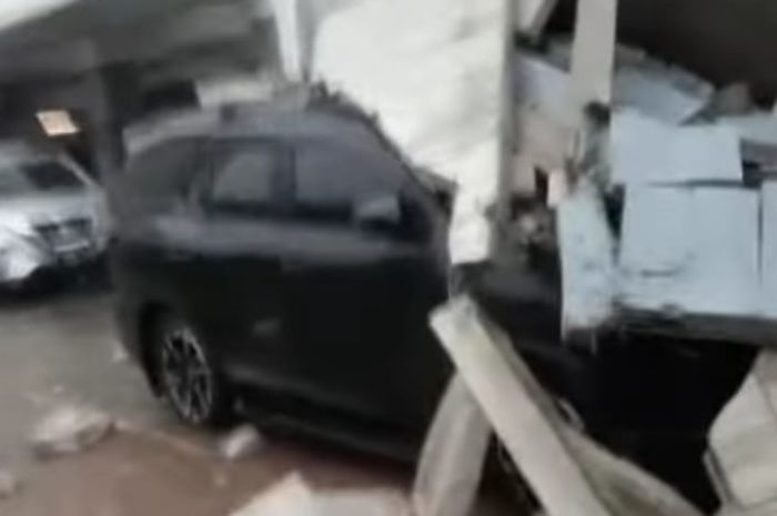 Sebuah mobil yang diduga Toyota Fortuner terimpa tembok roboh.