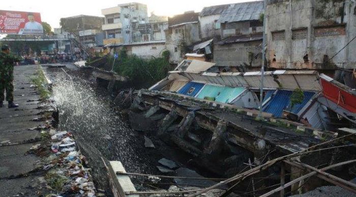 Bangunan pertokoan yang ikut ambles akibat jalan nasional di Jember, Jawa Timur terbelah