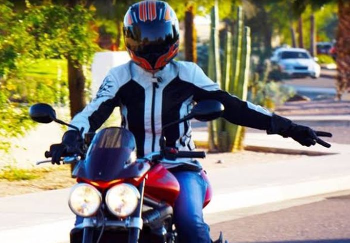 Ilustrasi pemotor berbelok dengan isyarat tangan