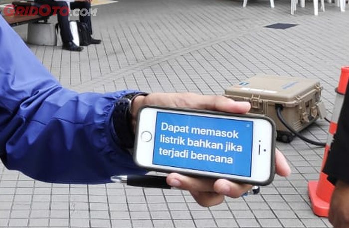 Petugas penjaga Toyota Mirai menjelaskan fungsi mobil lewat translate di handphone