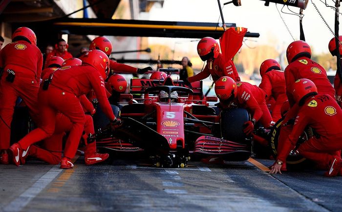 Kru tim Ferrari tengah melayani pit stop Sebastian Vettel pada tes pramusim F1 Barcelona